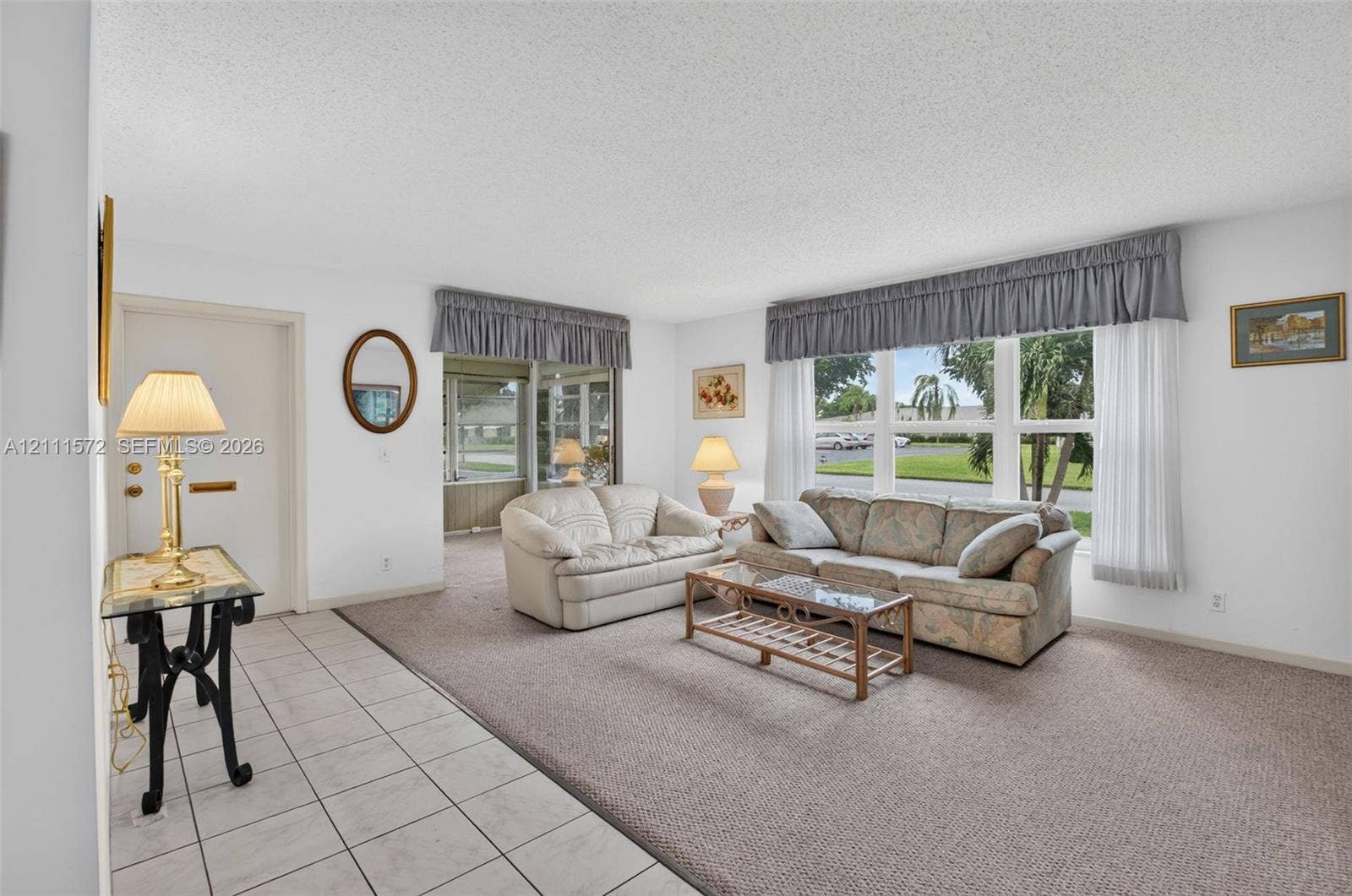 Neutral-toned ceramic tile flooring at entry, plush berber carpeting, and expansive multi-pane windows providing lots of natural light