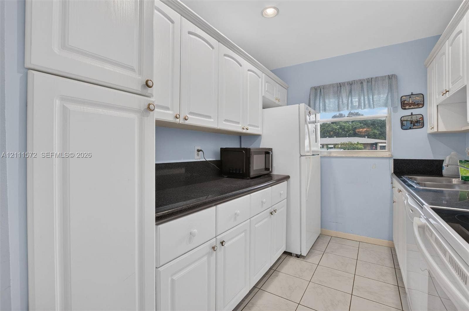 Kitchen featuring white cabinetry, stone-surface countertops, tile flooring, and recessed lighting