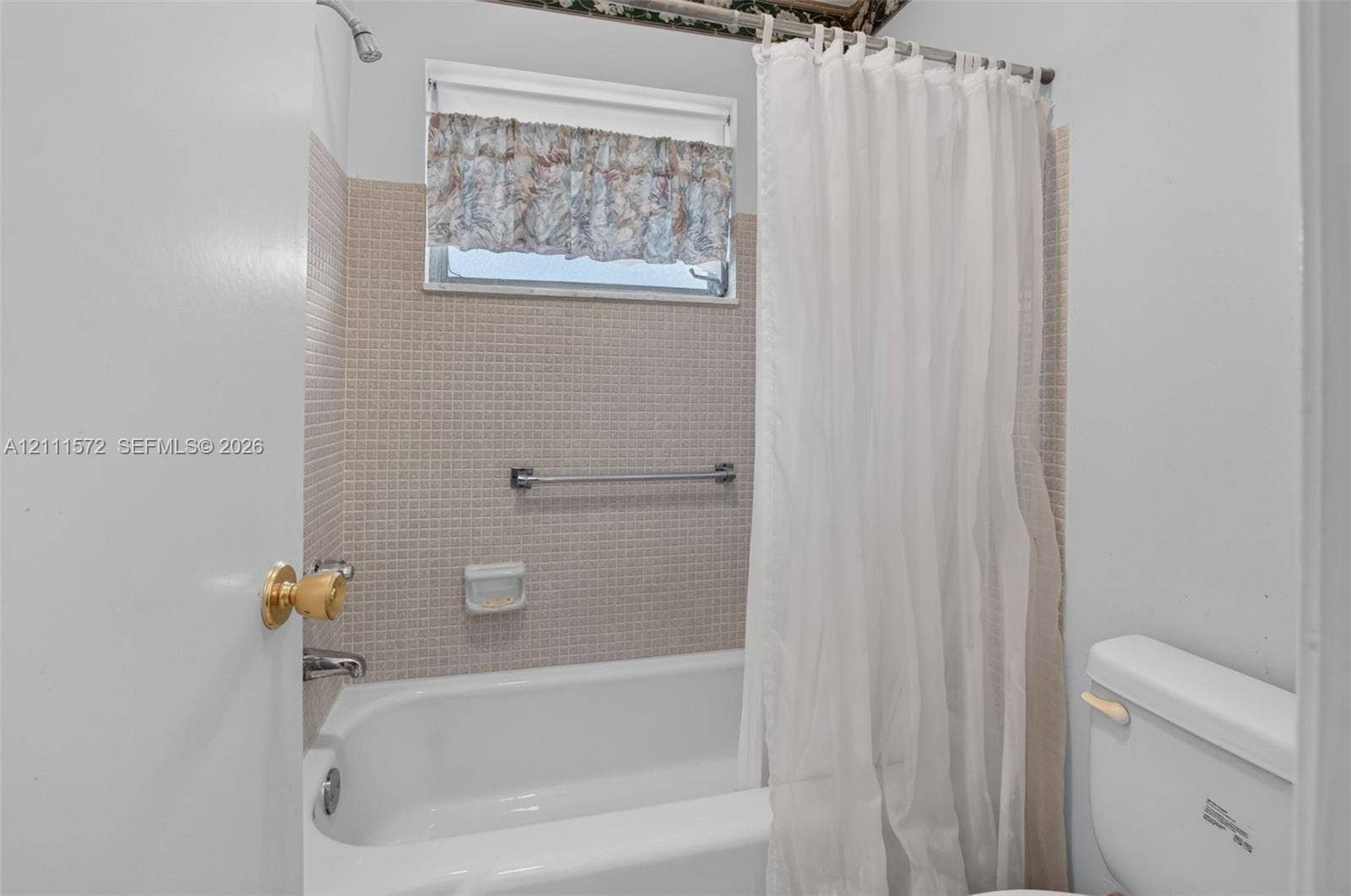 Bathroom featuring a bathtub with a tiled surround, integrated soap dish