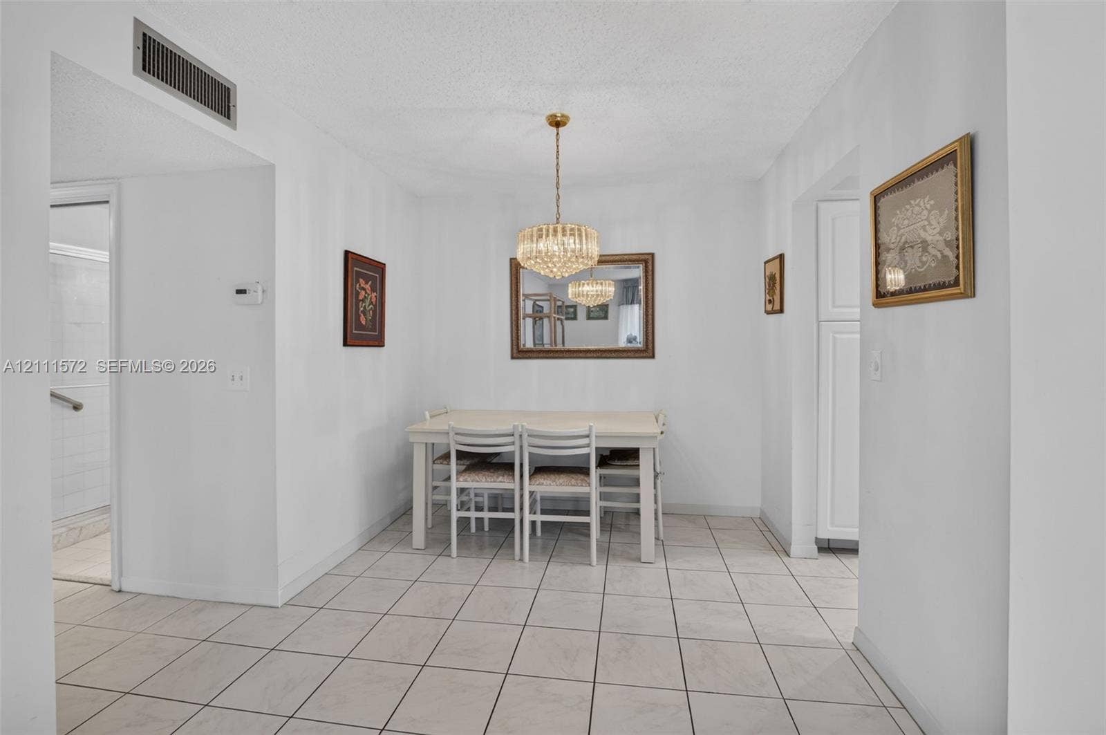 Dining area featuring, ceramic tile flooring and a tiered crystal chandelier