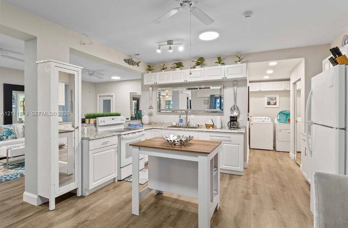 Kitchen featuring white shaker-style cabinetry, stone-finish countertops, wood-finish flooring, a portable kitchen island, and recessed lighting