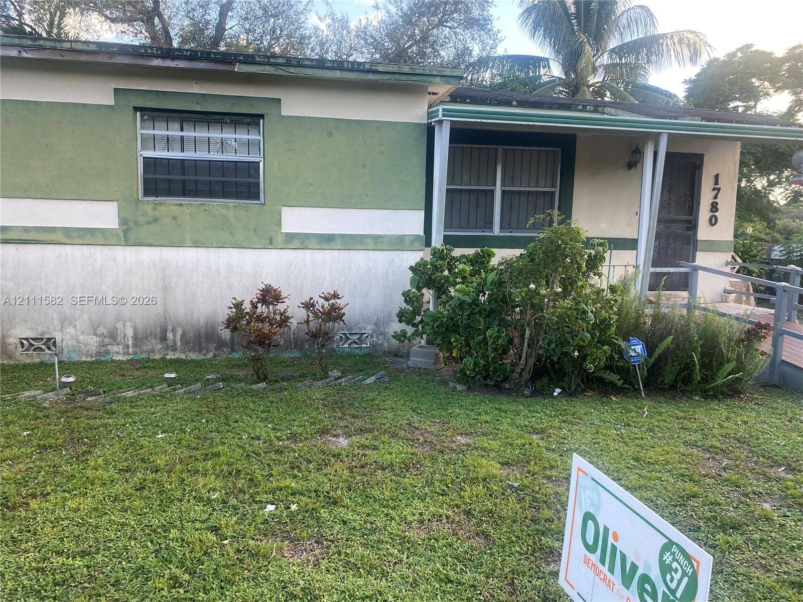 1780 NW 82nd Street, Miami, FL 33147 Single-story exterior featuring a covered front porch, metal-frame windows, and established landscaping