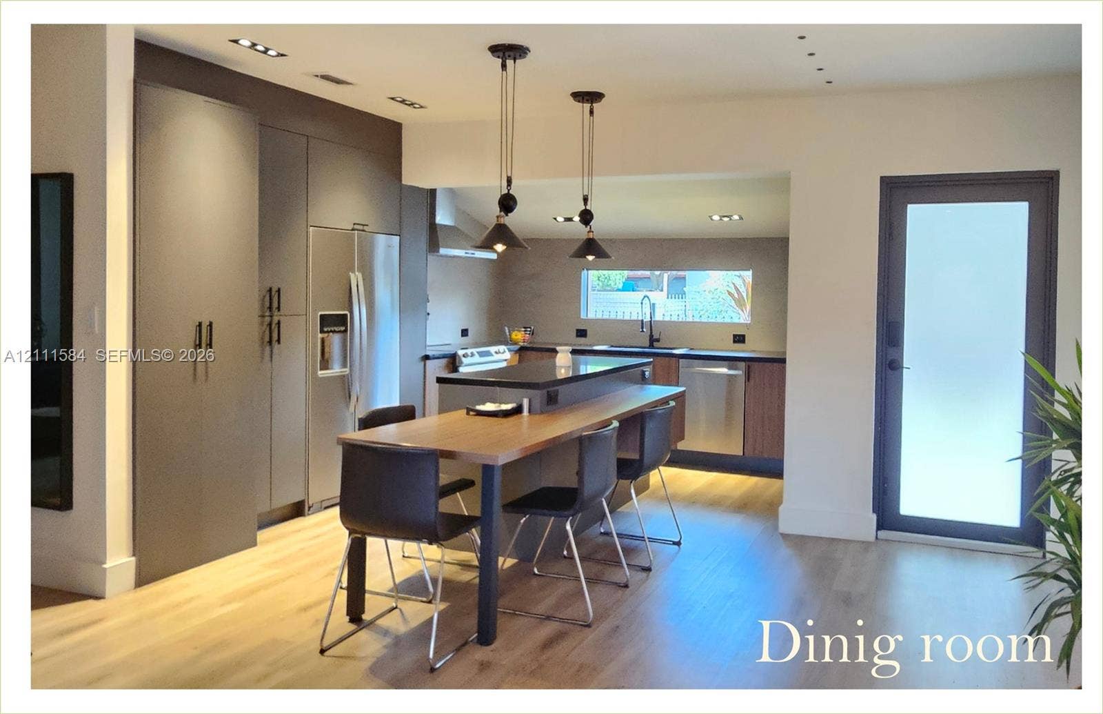 Kitchen featuring floor-to-ceiling cabinetry, stainless steel appliances, a central island with a wood-finish surface, recessed lighting, and wood-finish flooring