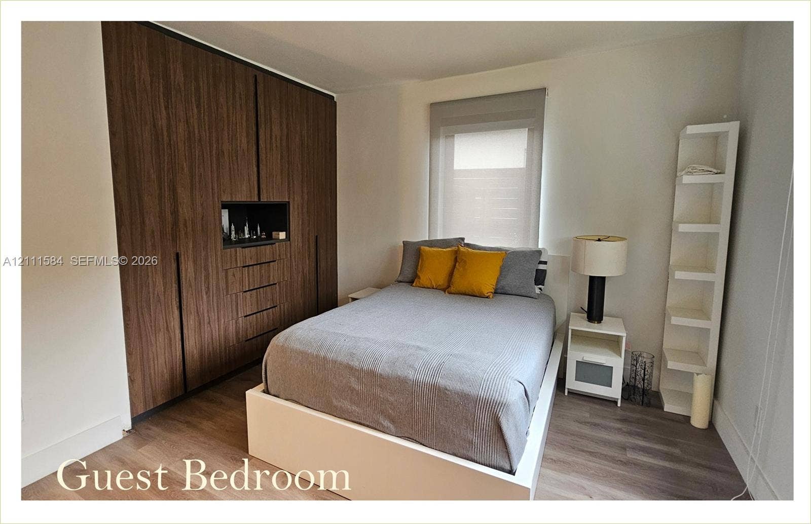 Floor-to-ceiling built-in wardrobe with wood-finish cabinetry, integrated shelving, and wood-finish flooring