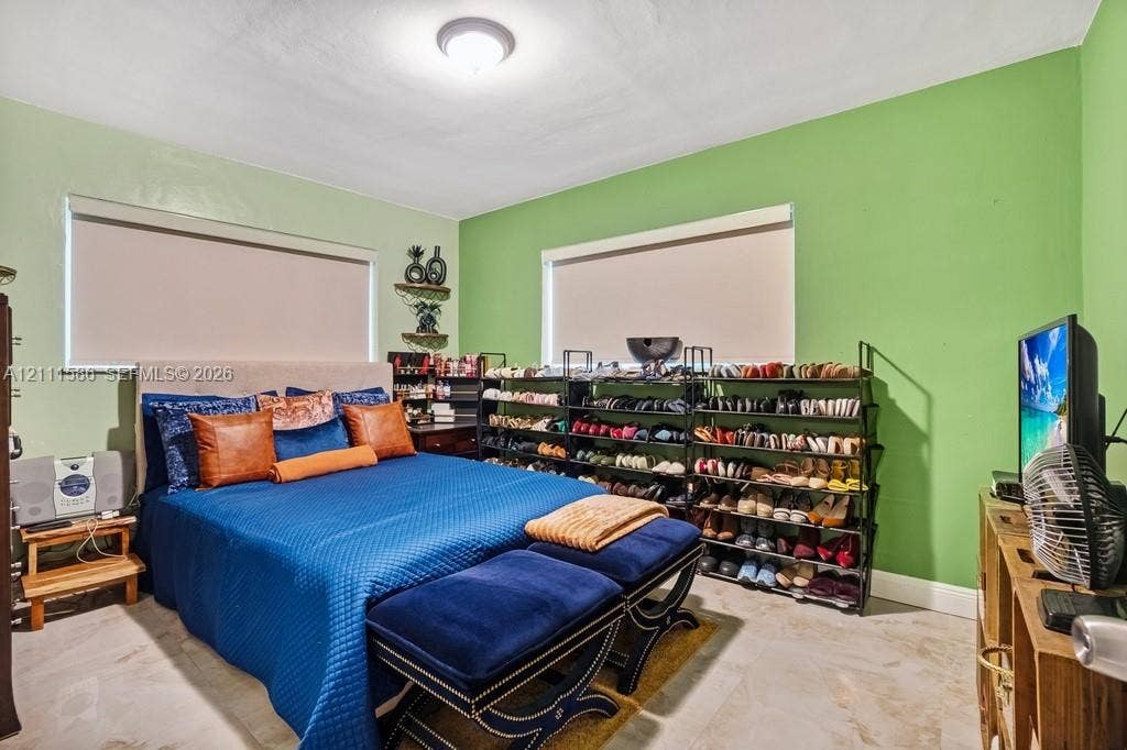 20431 NE 14th Court, Miami, FL 33179 Neutral-toned tile flooring, dual windows with fitted roller shades, and a ceiling-mounted light fixture