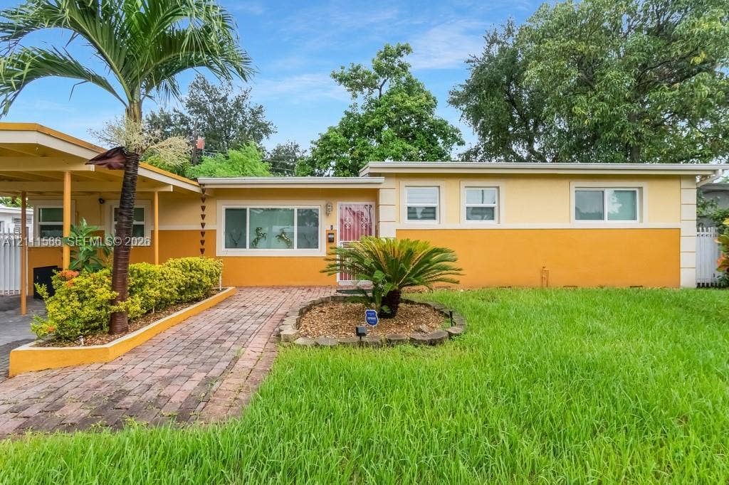 20431 NE 14th Court, Miami, FL 33179 Single-story exterior featuring a brick walkway, covered carport, and low-maintenance landscaping