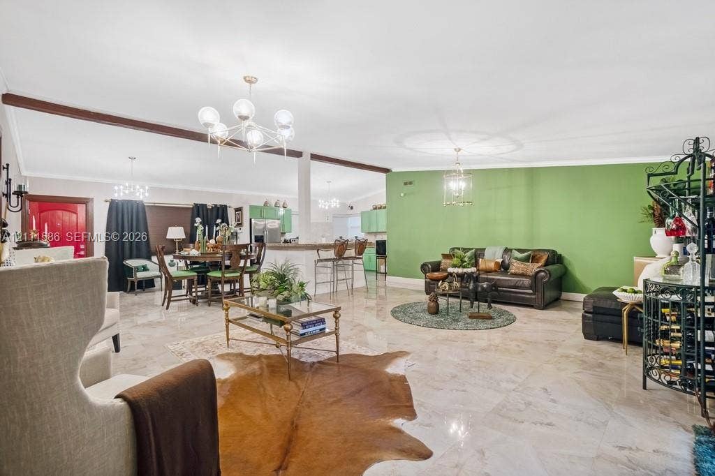 20431 NE 14th Court, Miami, FL 33179 Open-concept interior featuring high ceilings with exposed wood beams, polished stone flooring, and multiple tiered glass chandeliers