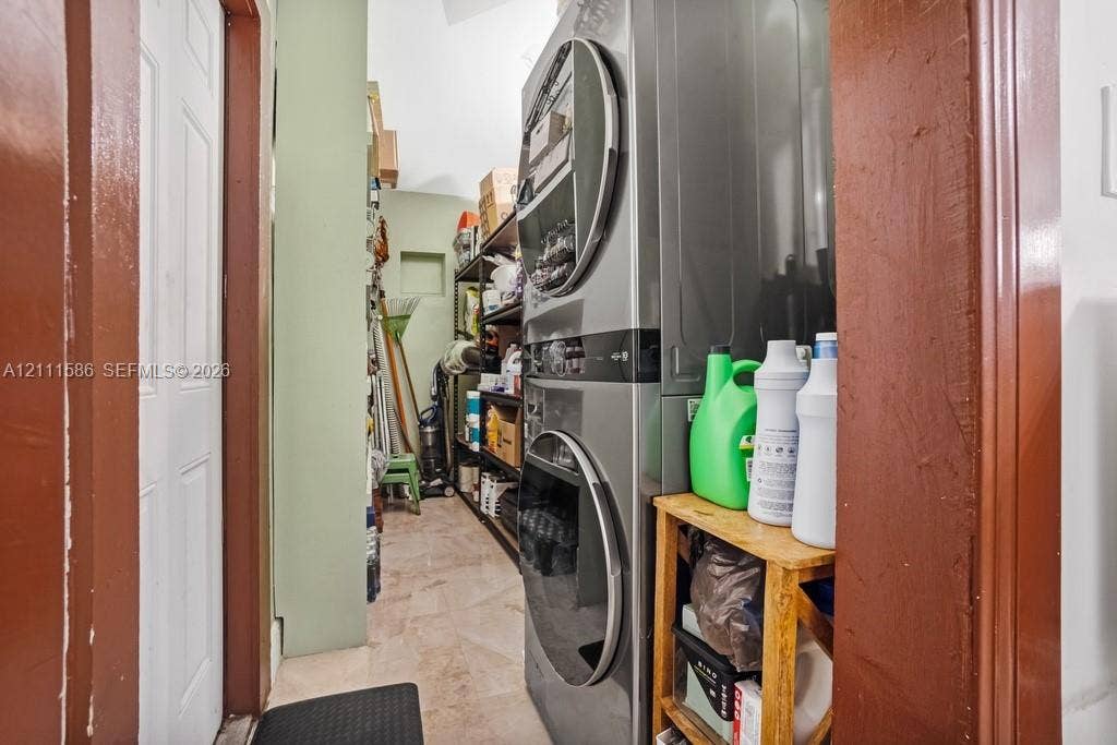 20431 NE 14th Court, Miami, FL 33179 Utility space featuring stacked laundry appliances and tile flooring
