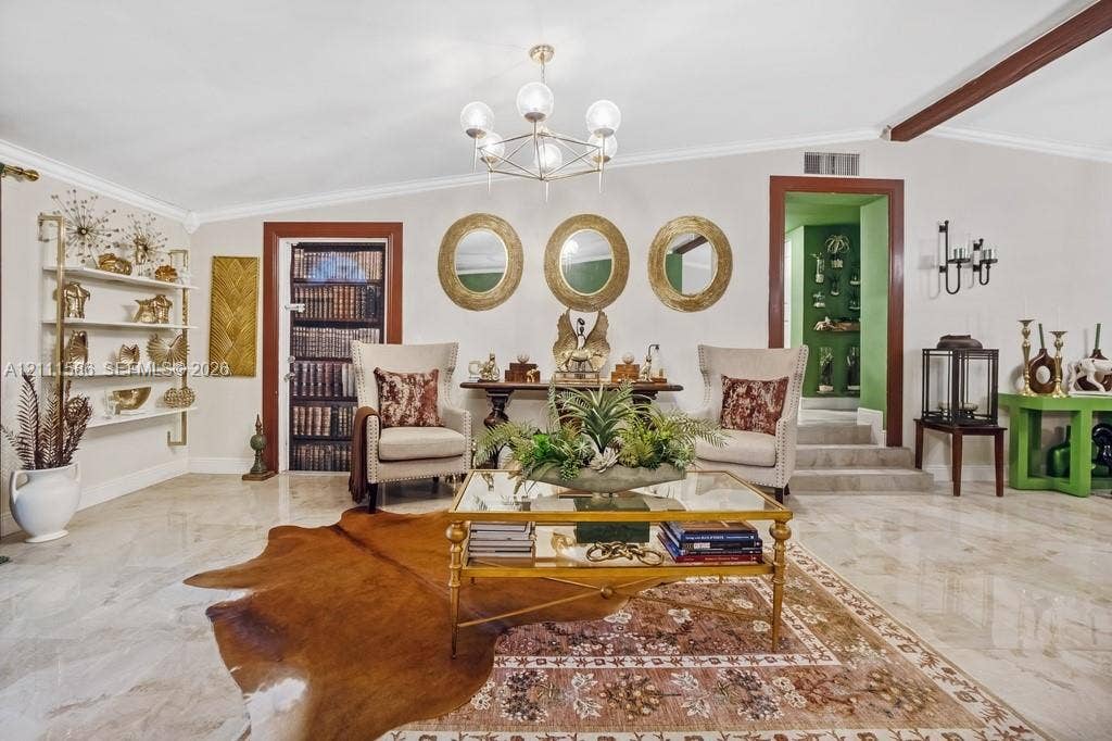 20431 NE 14th Court, Miami, FL 33179 Polished stone flooring, architectural wall-mounted shelving unit, contemporary multi-globe chandelier, and raised-level entryway with dark wood trim