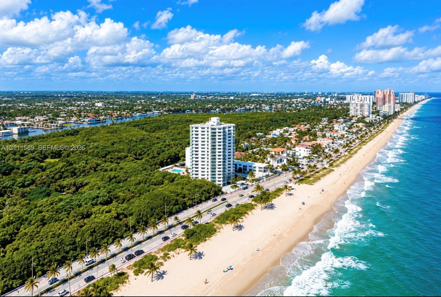 Aerial perspective featuring coastal proximity, high-rise residential structure, expansive oceanfront, and natural preserve