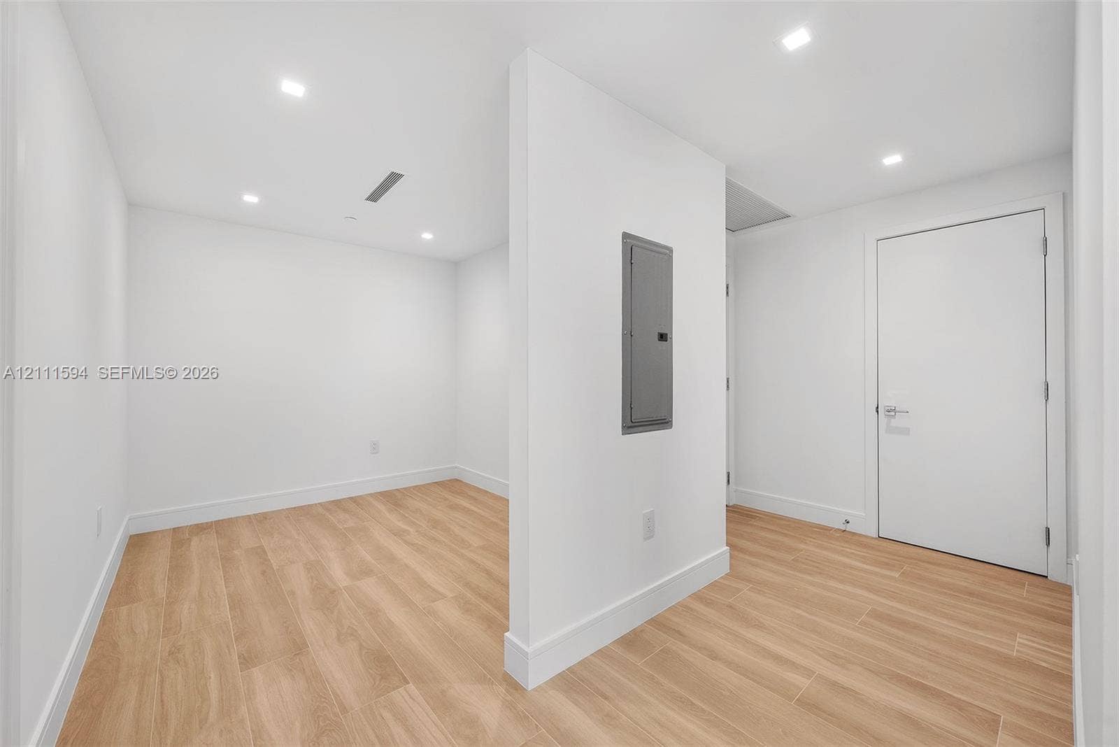 2411 Laguna Circle, #2506, North Miami, FL 33181 Interior room featuring wood-finish tile flooring, recessed ceiling lighting, and a central partition wall with an integrated electrical service panel