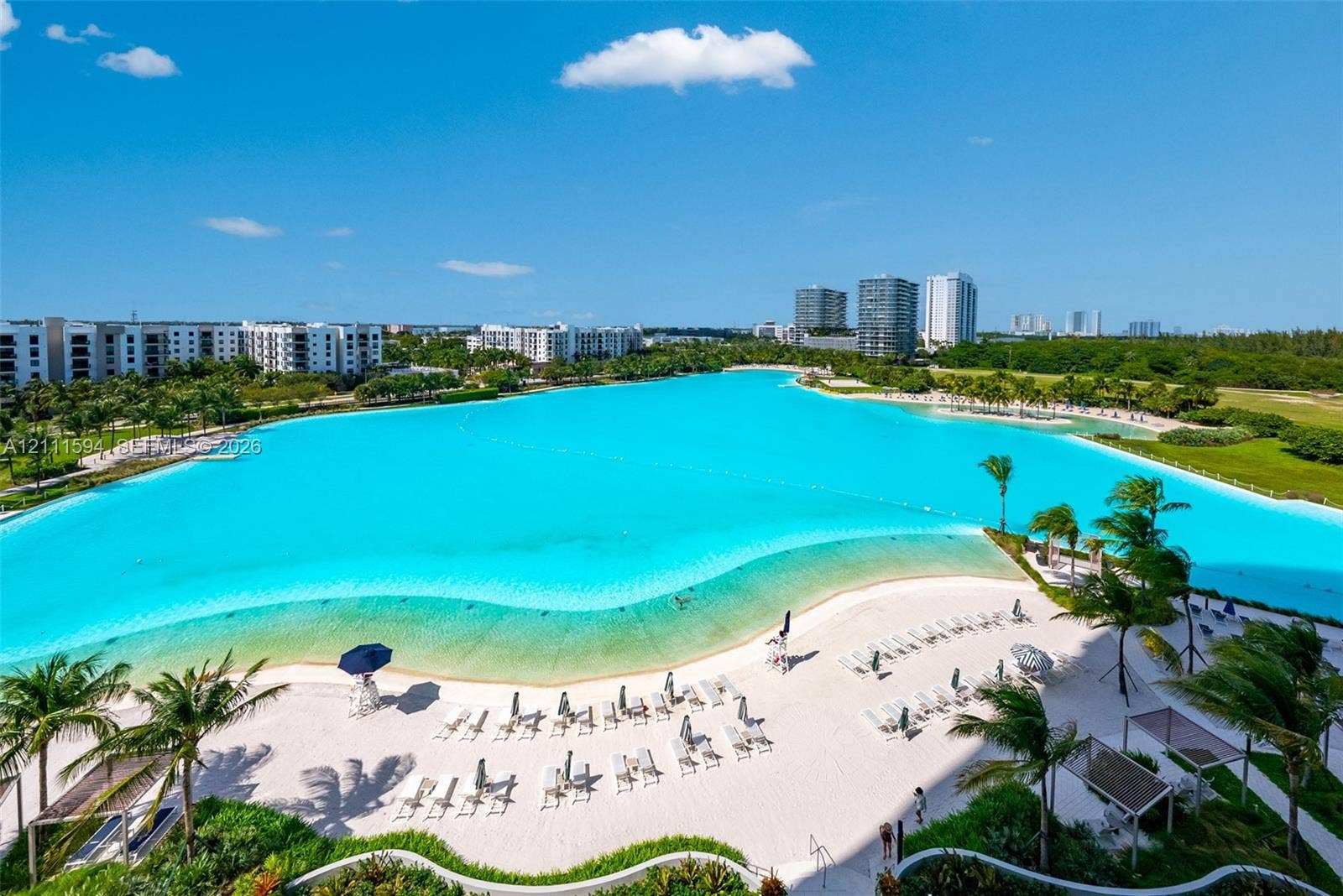 2411 Laguna Circle, #2506, North Miami, FL 33181 Expansive turquoise lagoon, white sand beach, and tropical landscaping