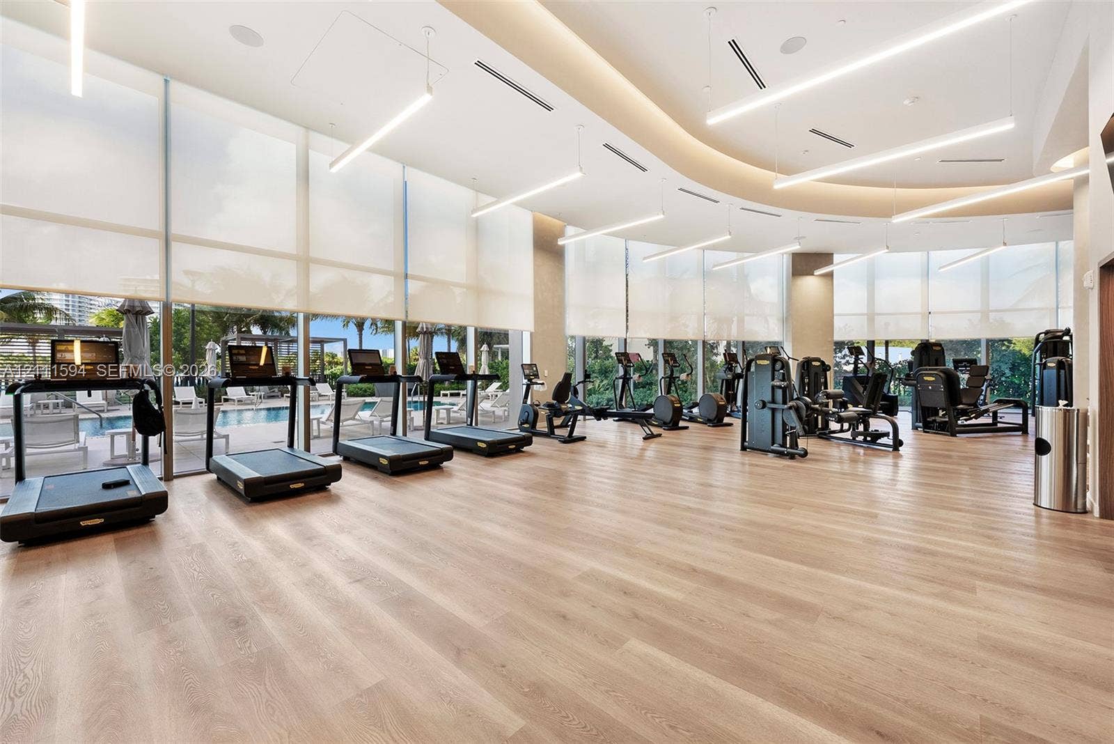 2411 Laguna Circle, #2506, North Miami, FL 33181 Fitness center featuring floor-to-ceiling windows, wood-finish flooring, recessed lighting, and linear suspended light fixtures