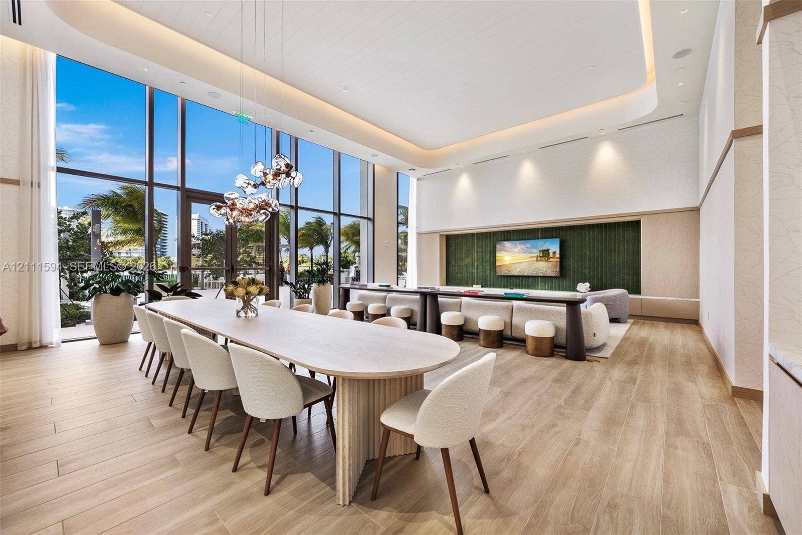 2411 Laguna Circle, #2506, North Miami, FL 33181 Expansive room featuring floor-to-ceiling windows, wood-finish flooring, recessed cove lighting, and a green textured accent wall with integrated cabinetry