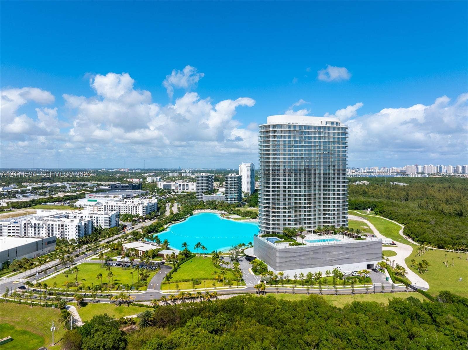2411 Laguna Circle, #2506, North Miami, FL 33181 High-rise residential tower featuring a glass facade, private balconies, and a podium-level swimming pool