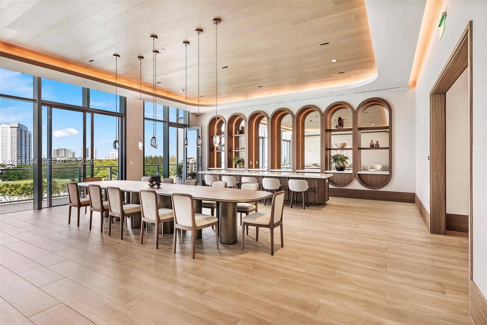2411 Laguna Circle, #2506, North Miami, FL 33181 Wood-finish flooring, coved ceiling with recessed lighting, floor-to-ceiling glass paneling, and custom built-in arched cabinetry featuring stone countertops