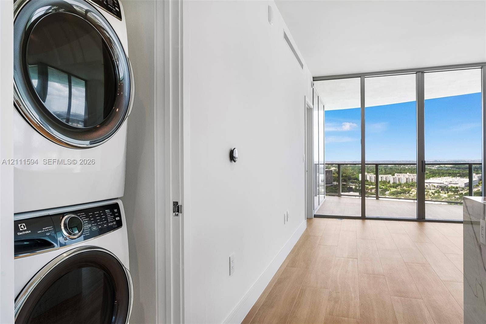 2411 Laguna Circle, #2506, North Miami, FL 33181 Stacked laundry appliances, wood-finish flooring, floor-to-ceiling windows, and private balcony