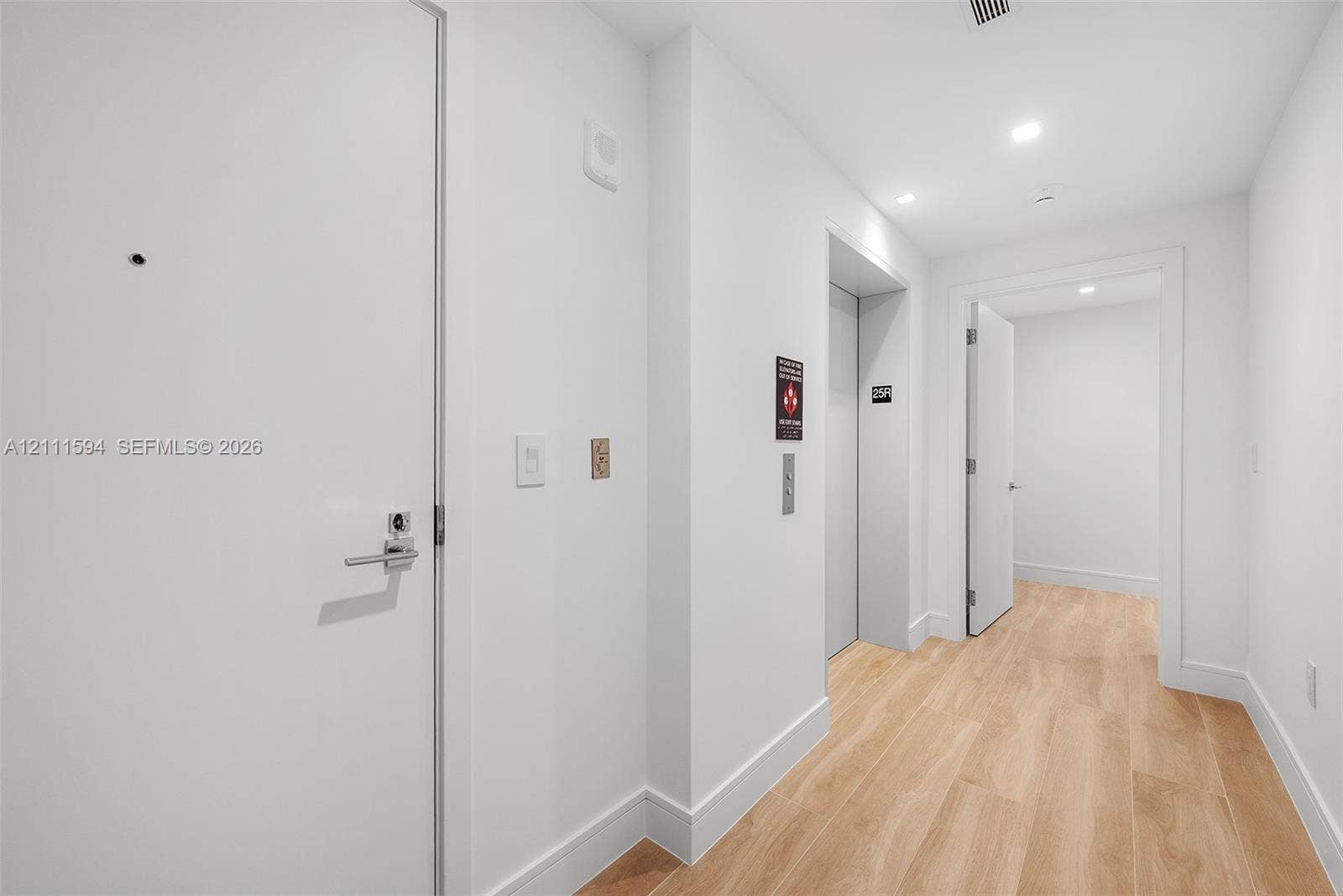 2411 Laguna Circle, #2506, North Miami, FL 33181 Interior hallway featuring wood-finish flooring, recessed lighting, and a dedicated elevator entrance