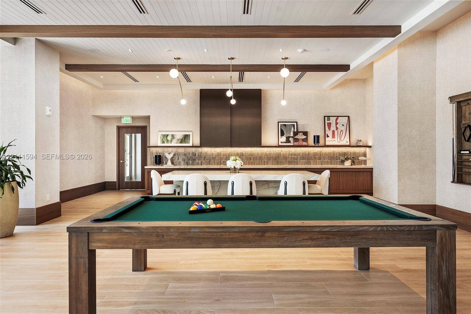 2411 Laguna Circle, #2506, North Miami, FL 33181 Wood-finish flooring, exposed ceiling beams, stone-top island with integrated cabinetry, tile backsplash, and recessed lighting
