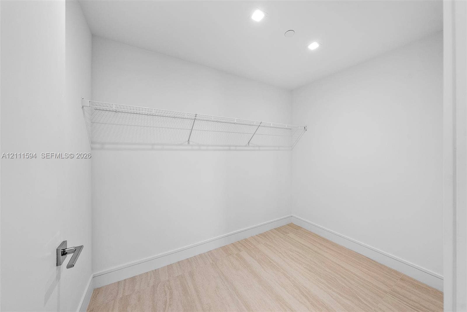 2411 Laguna Circle, #2506, North Miami, FL 33181 Walk-in closet featuring light wood-finish flooring, white walls, recessed ceiling lighting, and white wire shelving