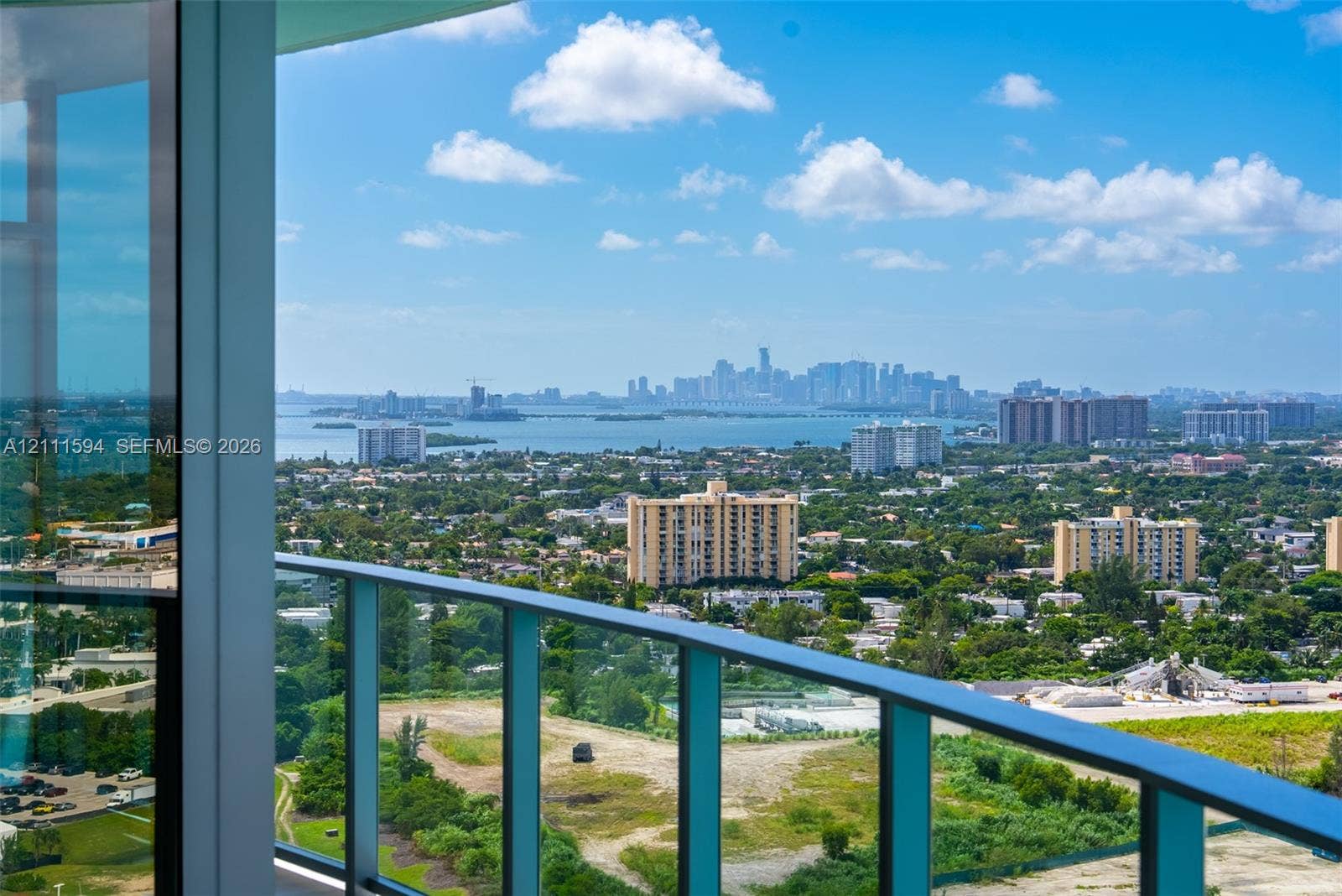 2411 Laguna Circle, #2506, North Miami, FL 33181 Expansive terrace with floor-to-ceiling glass paneling and a metal railing, providing a panoramic cityscape and water horizon