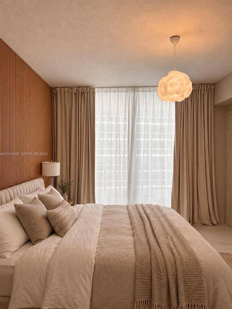 Vertical wood-slat accent wall, full-height window drapery, and suspended textured pendant lighting