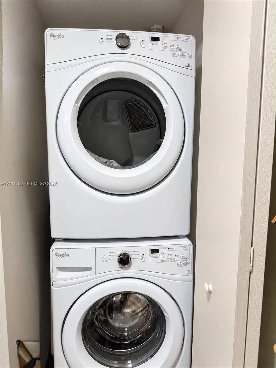 Stackable Whirlpool washer and dryer unit with front-loading glass doors and digital control panels