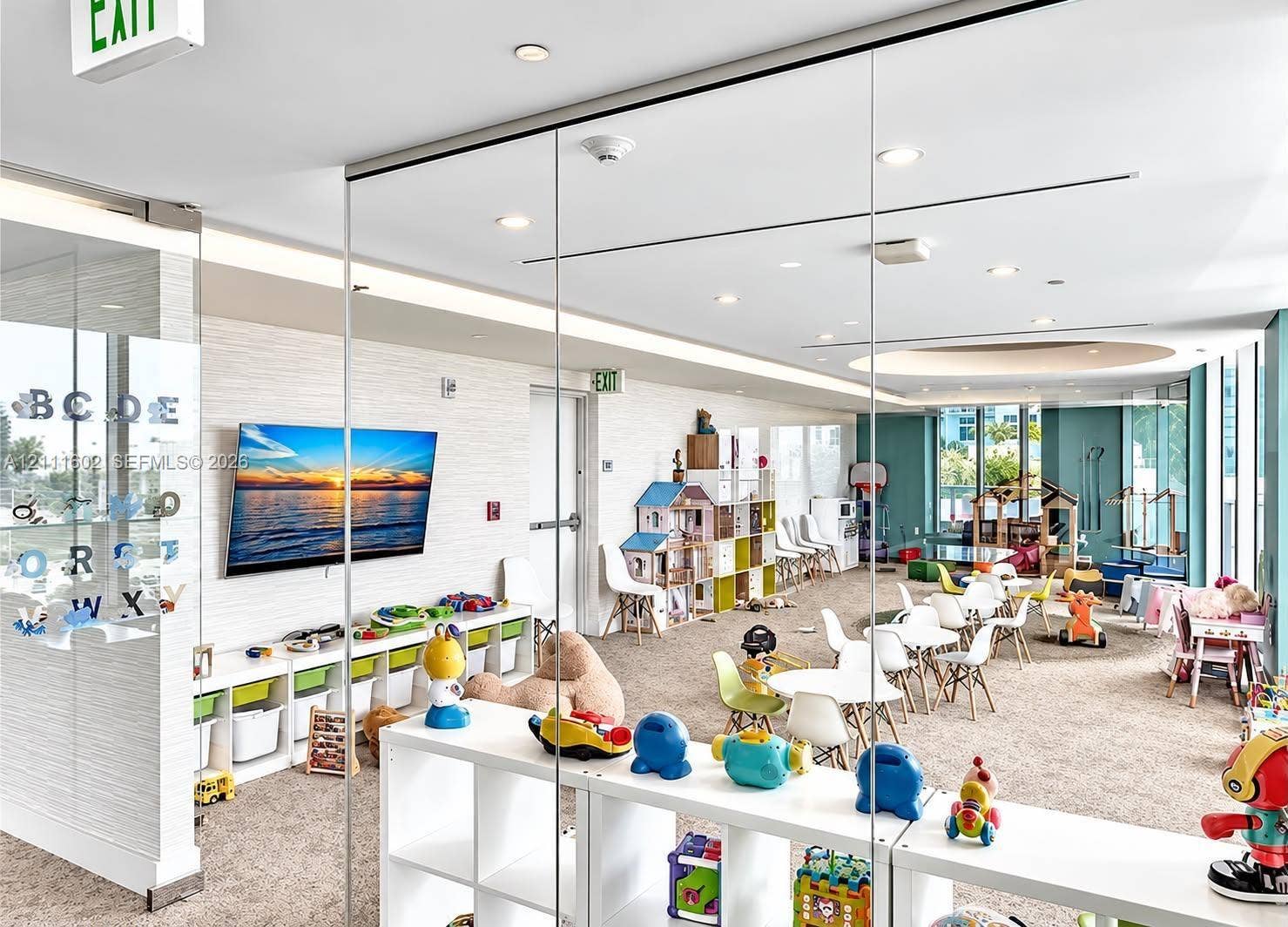 Floor-to-ceiling glass wall partitions, neutral carpeting, recessed lighting, and expansive windows