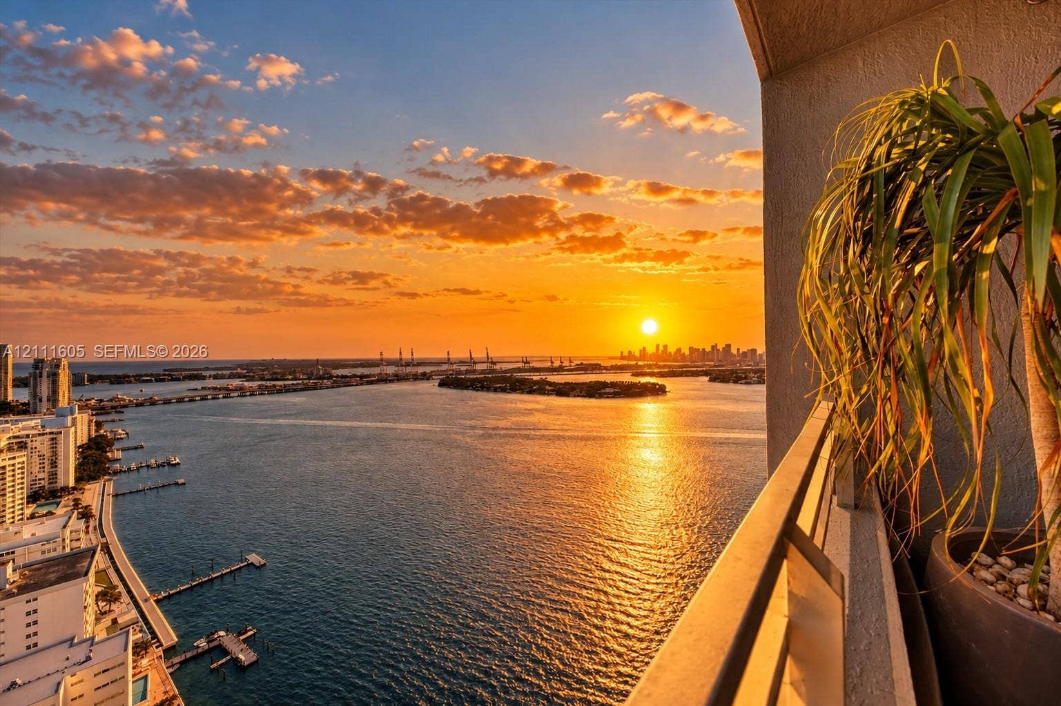 Balcony featuring a metal railing and panoramic scenery of the bay, bridges, and city skyline