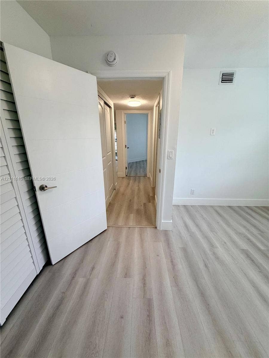 Wood-finish flooring, multi-panel interior doors, and flush-mount ceiling lighting