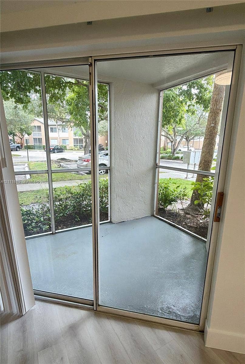 Screened-in patio with concrete flooring, metal framing, and sliding glass entry door