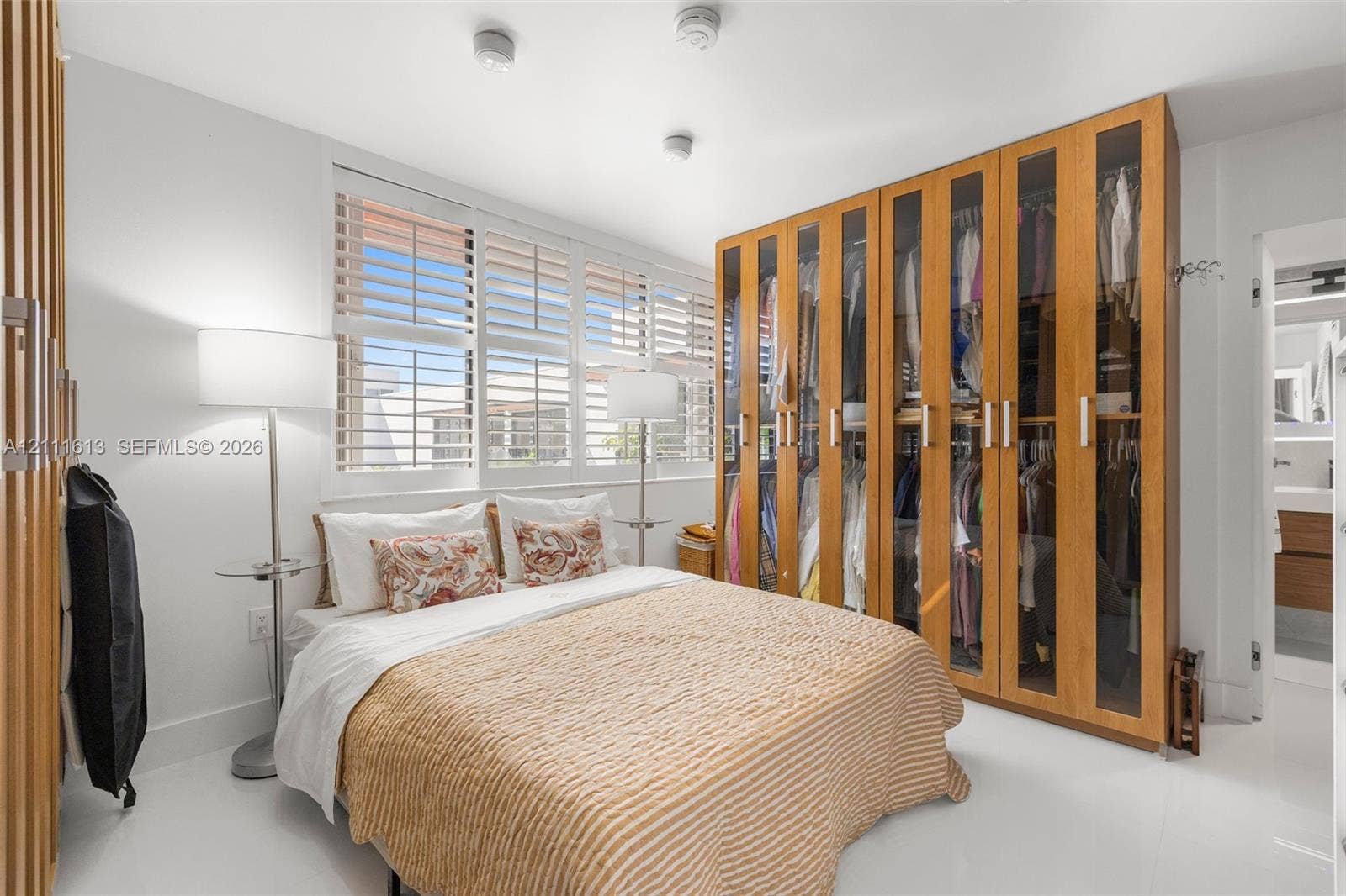 Built-in floor-to-ceiling wood cabinetry with glass panel doors, interior shelving, and recessed ceiling lighting