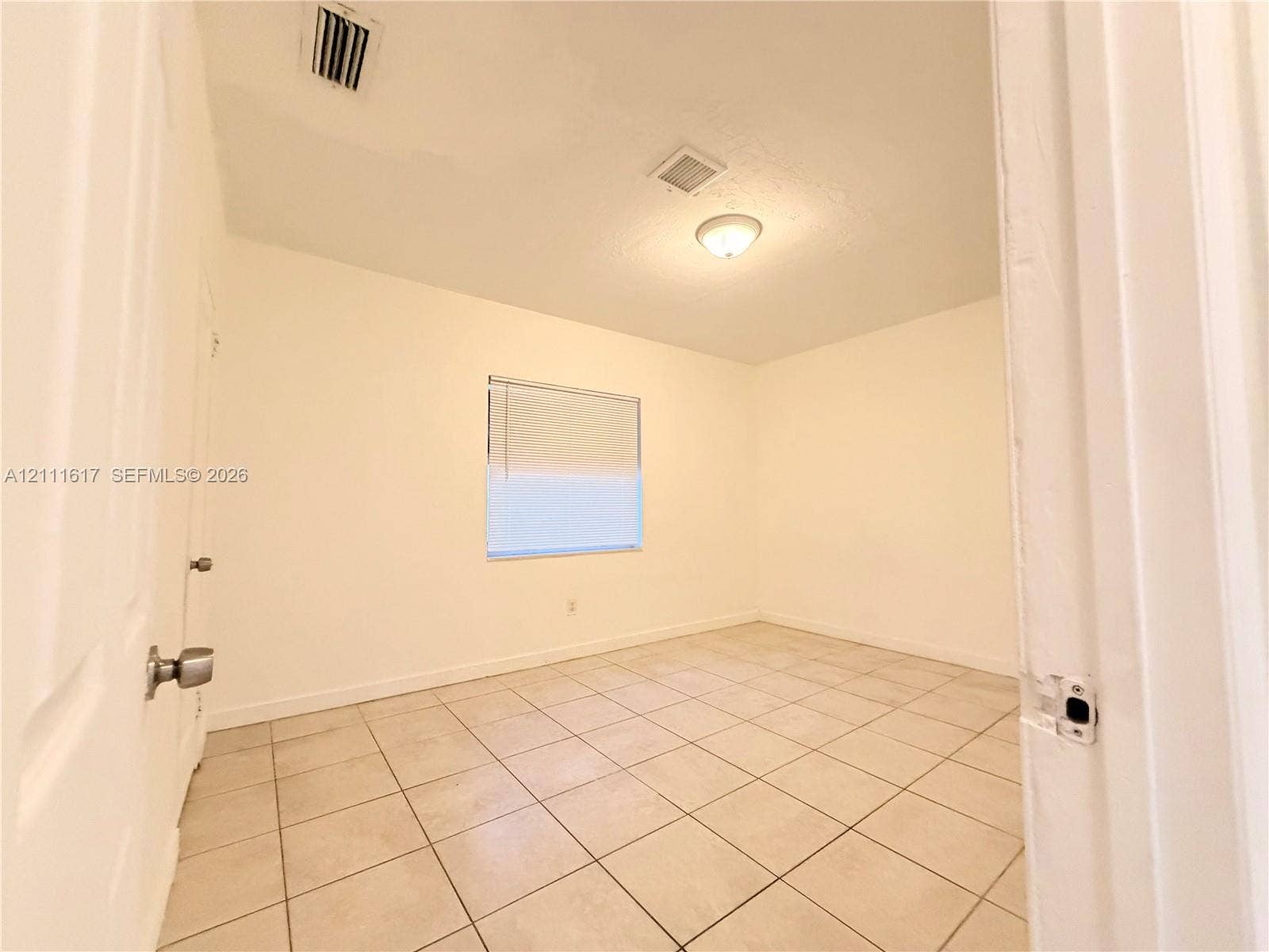 Room featuring neutral wall finishes, tile flooring, and a single window with integrated blinds