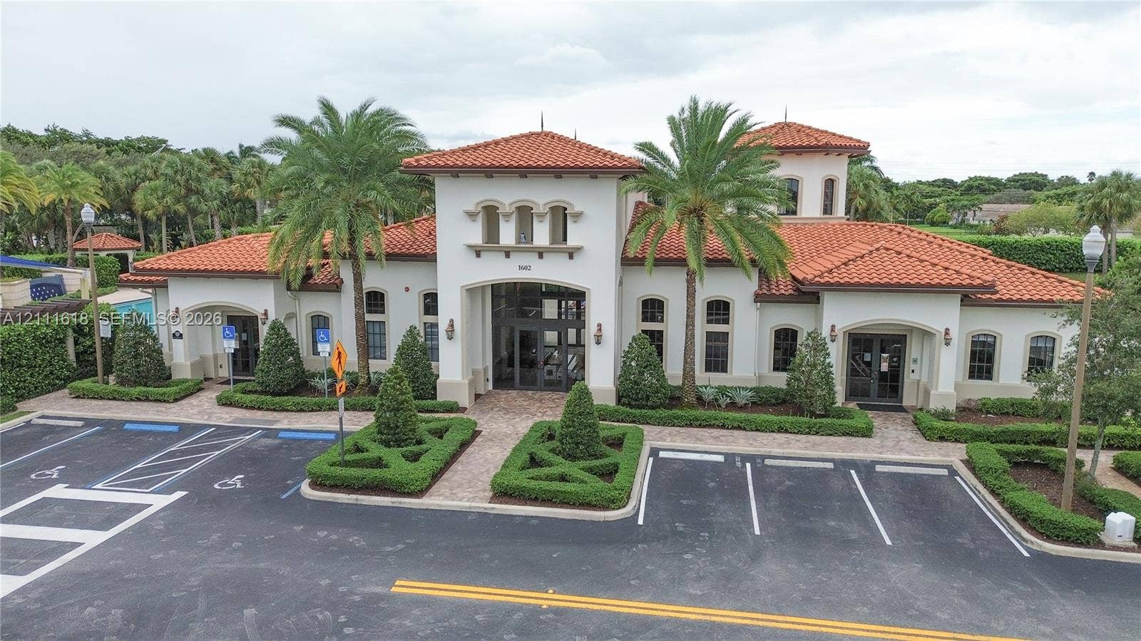 1423 SW 115th Avenue, #NA, Pembroke Pines, Pembroke Pines, FL 33025 Mediterranean-style exterior featuring a terra-cotta tile roof, stucco facade, arched windows, and manicured landscaping