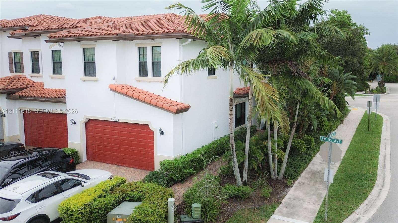 1423 SW 115th Avenue, #NA, Pembroke Pines, Pembroke Pines, FL 33025 Mediterranean-style exterior featuring white stucco finish, red tile roofing, and prominent multi-car garage with articulated doors
