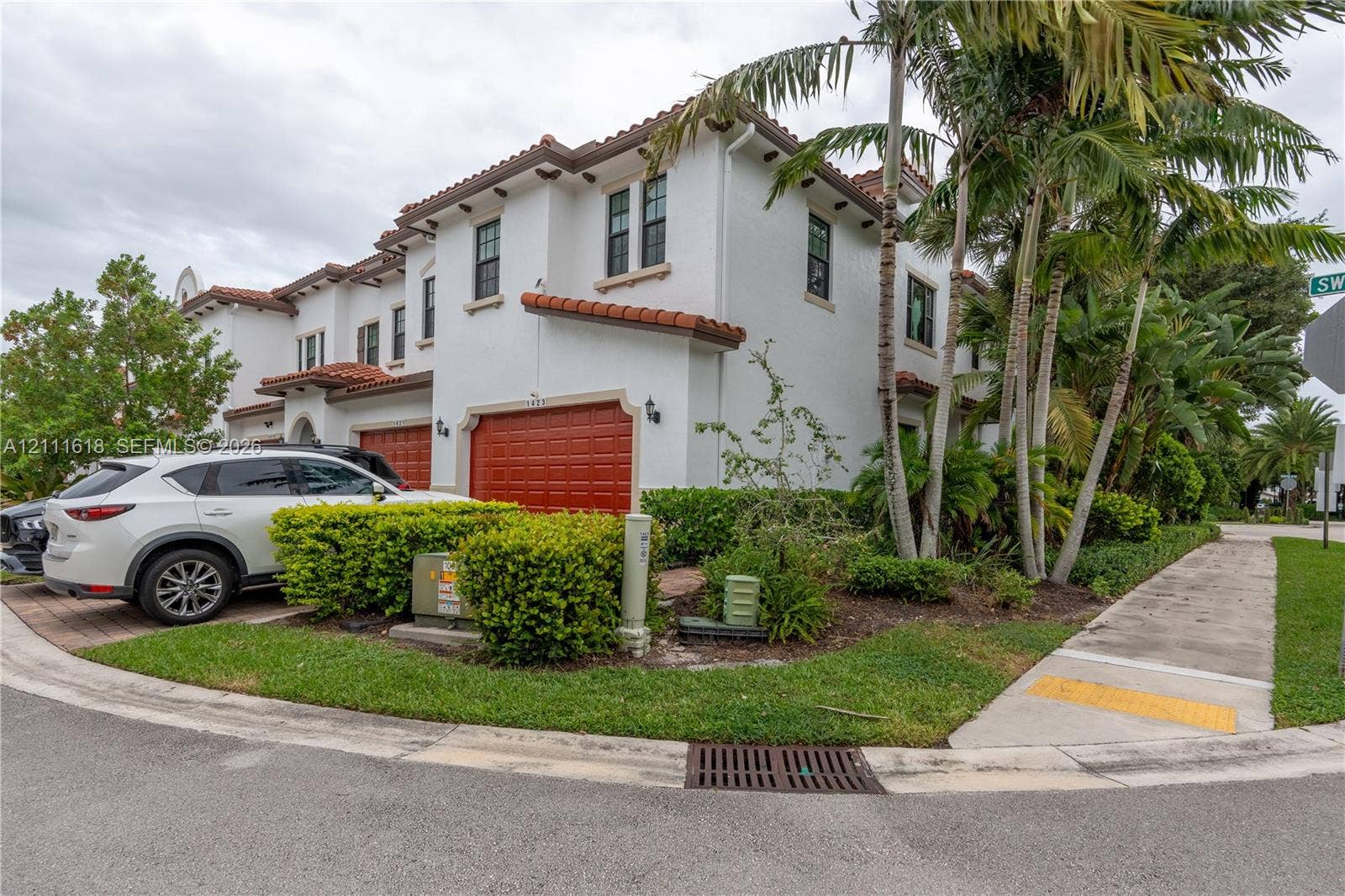 1423 SW 115th Avenue, #NA, Pembroke Pines, Pembroke Pines, FL 33025 Mediterranean-style exterior featuring a white stucco facade, multi-level terracotta tile roofing, and arched garage entryways