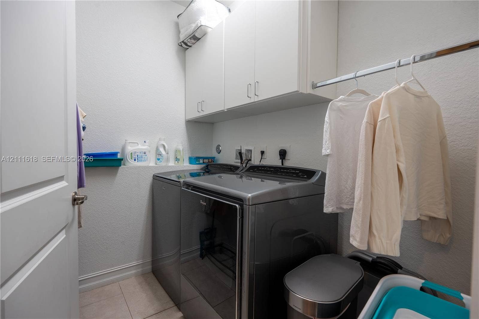 1423 SW 115th Avenue, #NA, Pembroke Pines, Pembroke Pines, FL 33025 Laundry area featuring white built-in upper cabinetry, tile flooring, and a metal clothing rod
