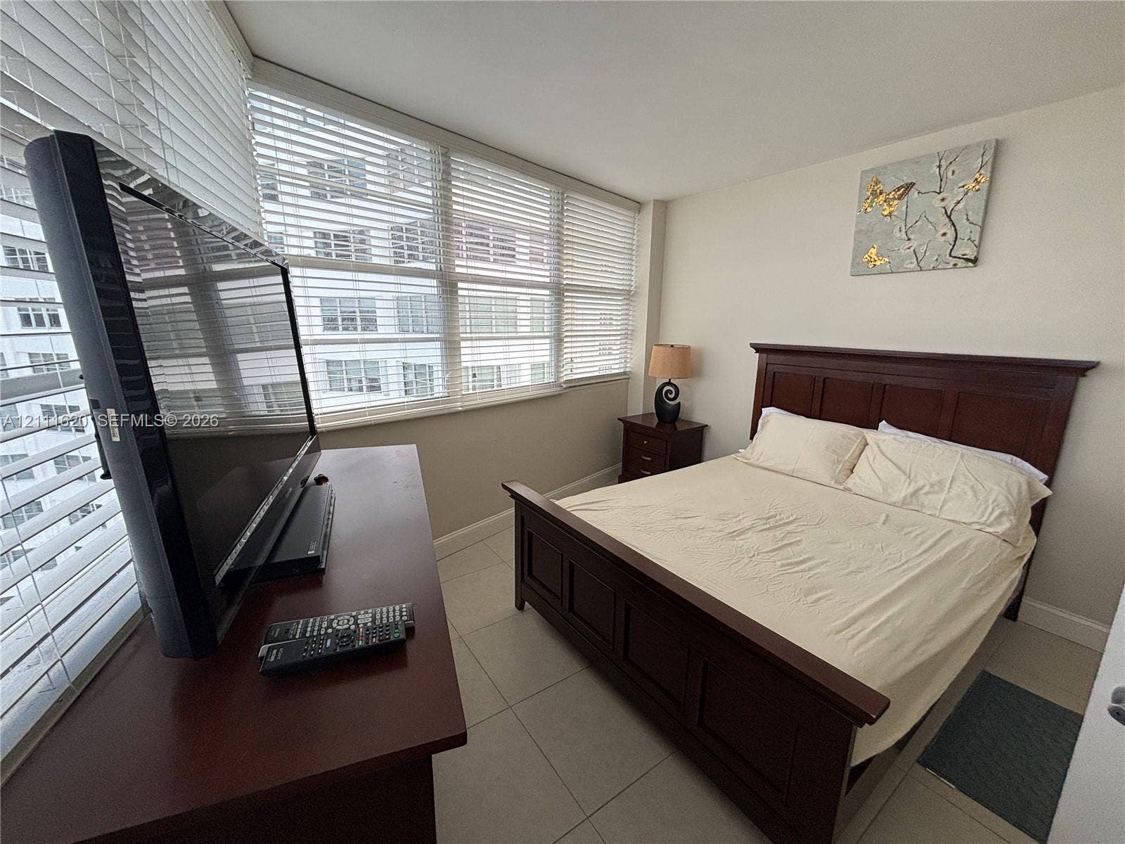 Floor-to-ceiling windows with horizontal blinds and large-format tile flooring