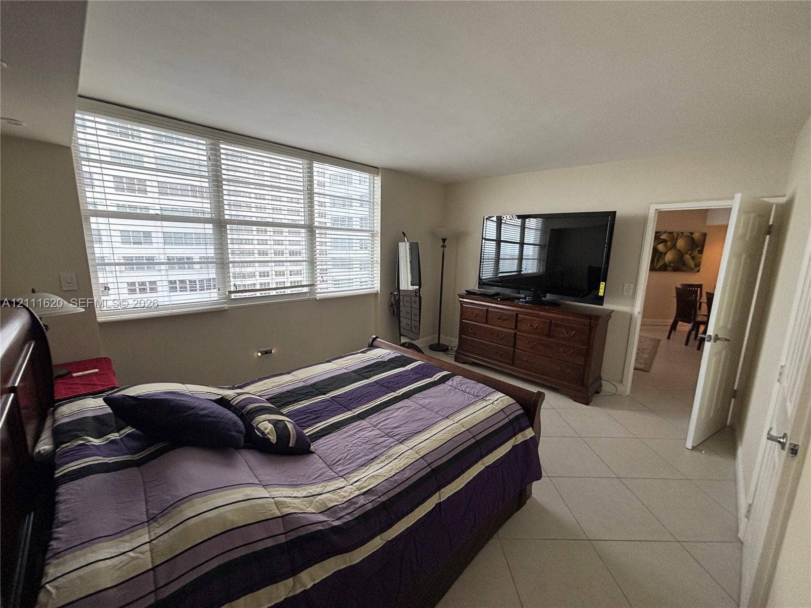 Expansive floor-to-ceiling windows with horizontal blinds and large-format tile flooring