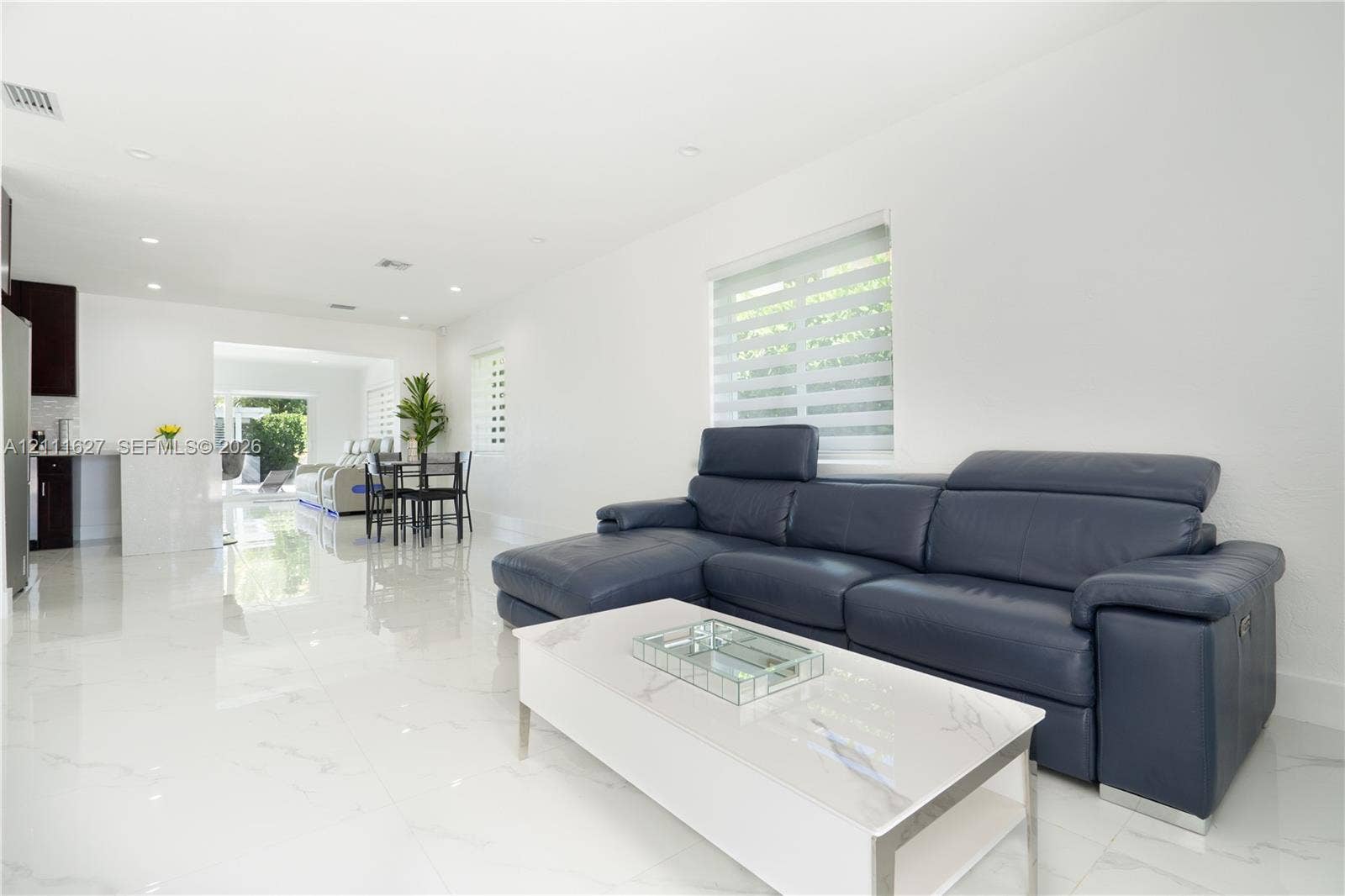 Large-format porcelain tile flooring, recessed ceiling lighting, and dual-layered window shades