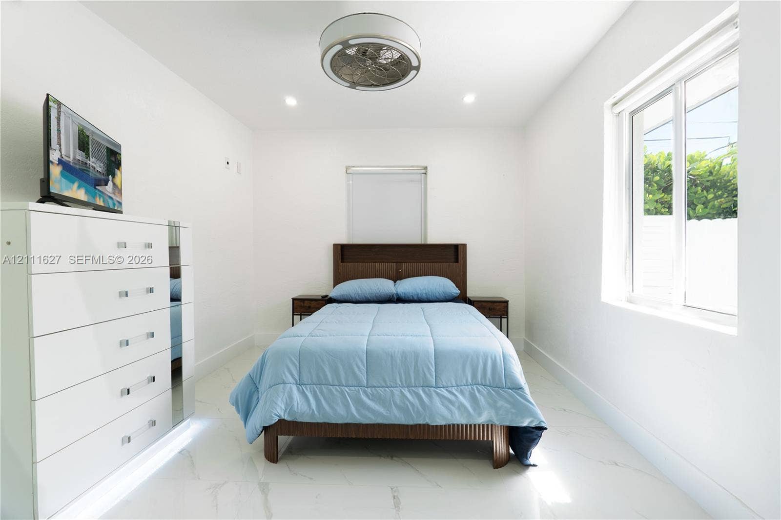 Interior space featuring polished white tile flooring, recessed lighting, and a contemporary circular flush-mount ceiling fan