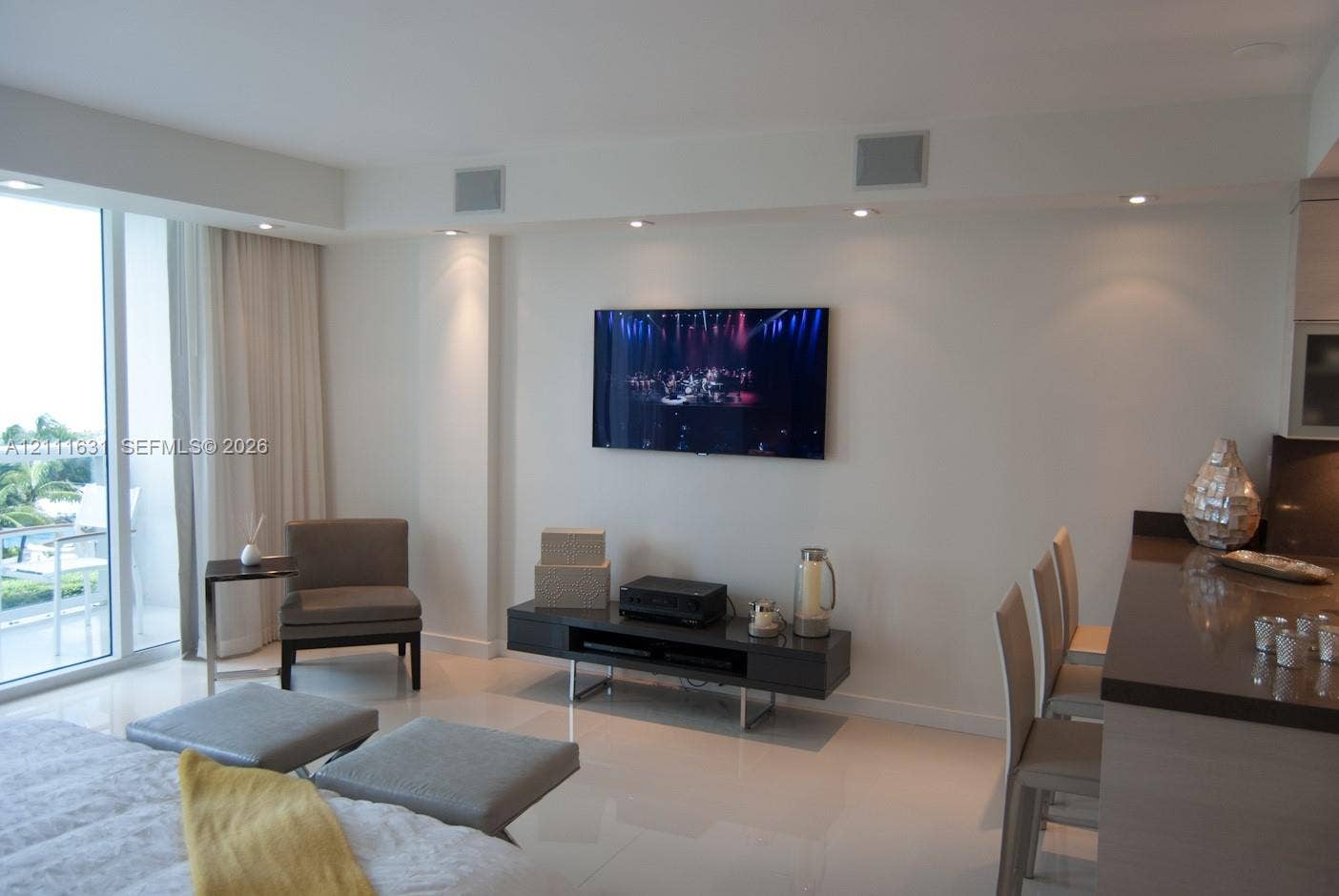Open-concept interior featuring large-format tile flooring, recessed ceiling lighting, and floor-to-ceiling glass sliding doors