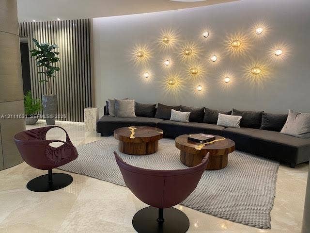 Polished stone flooring, textured wood-slat wall paneling, and custom circular wall-mounted lighting fixtures