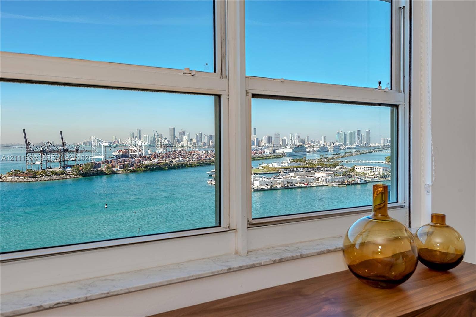 90 Alton Road, #2410, Miami Beach, FL 33139 Large-pane windows with white framing and a stone sill overlooking the waterfront and cityscape