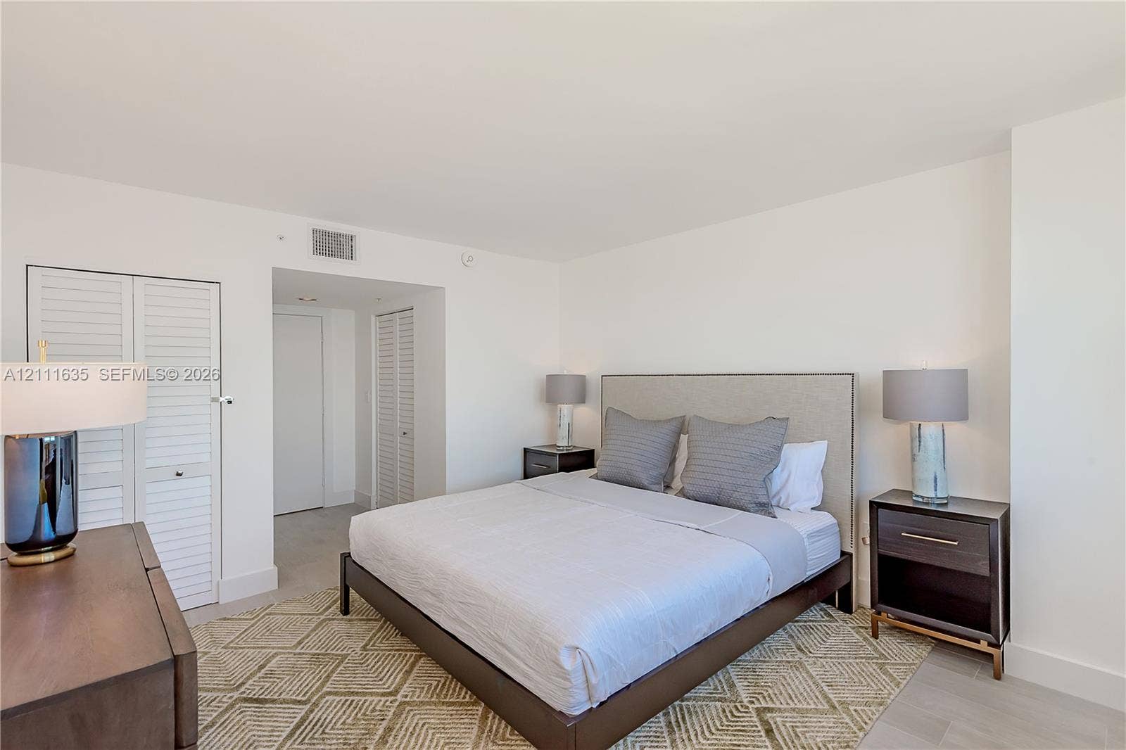 90 Alton Road, #2410, Miami Beach, FL 33139 Bedroom featuring neutral wall finishes, tile flooring, and louvered closet doors