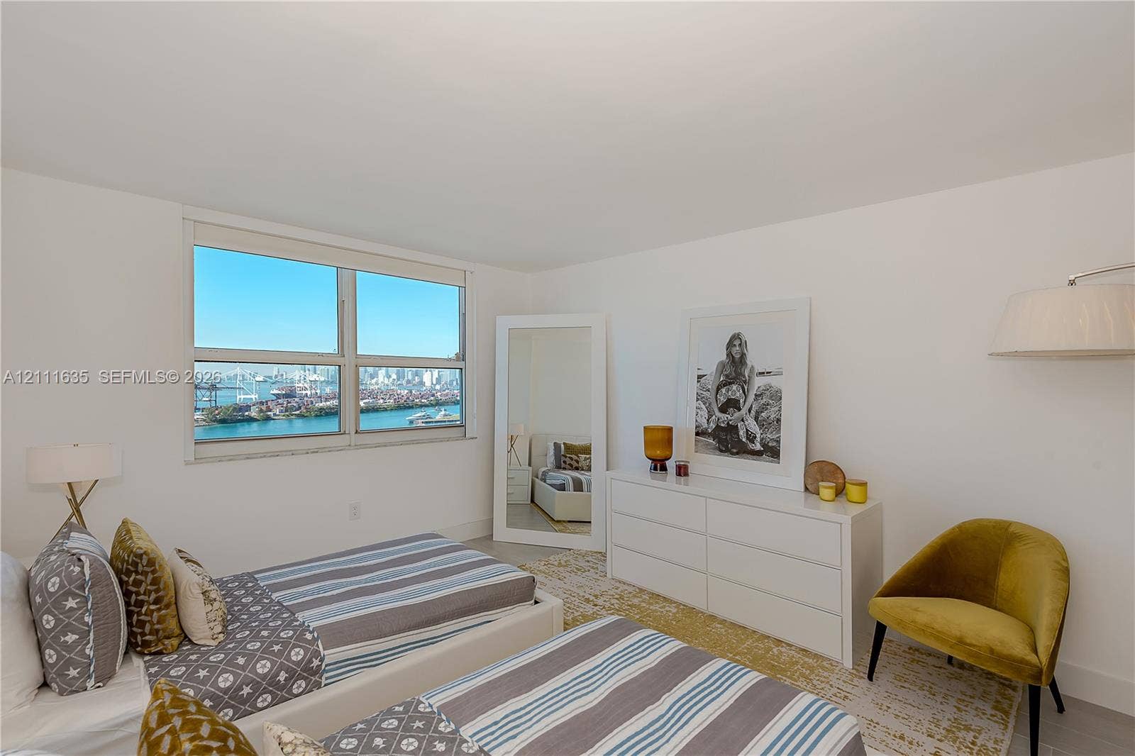 90 Alton Road, #2410, Miami Beach, FL 33139 Interior space featuring large-scale windows with water and skyline scenery and neutral wall finishes