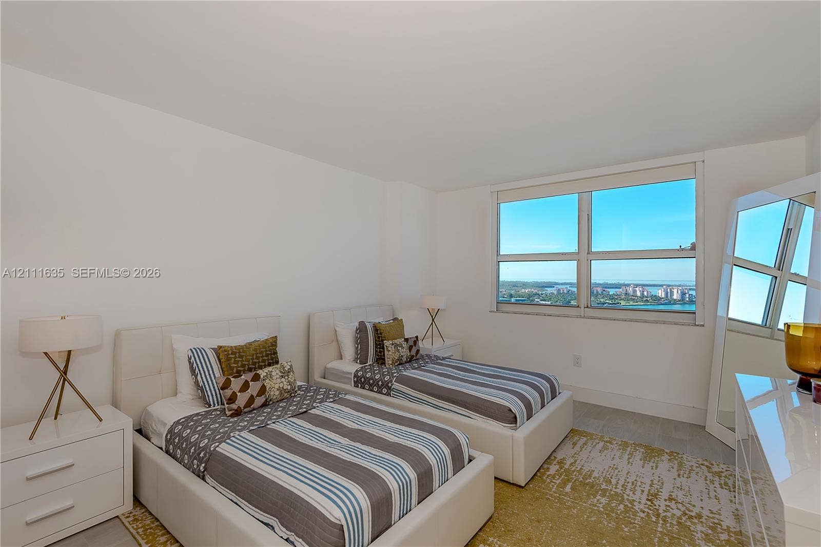 90 Alton Road, #2410, Miami Beach, FL 33139 Large multi-pane window with water and coastal cityscape scenery, neutral wall finish, and tile flooring