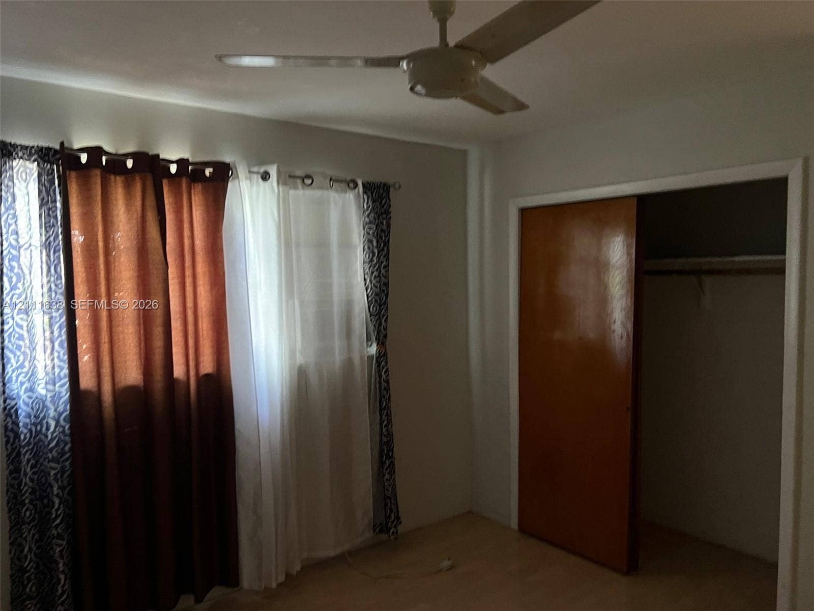 4841 SW 45th Avenue, #2, Hollywood, Hollywood, FL 33314 Neutral-toned interior space featuring wood-finish flooring, a ceiling-mounted fan, and a sliding closet door
