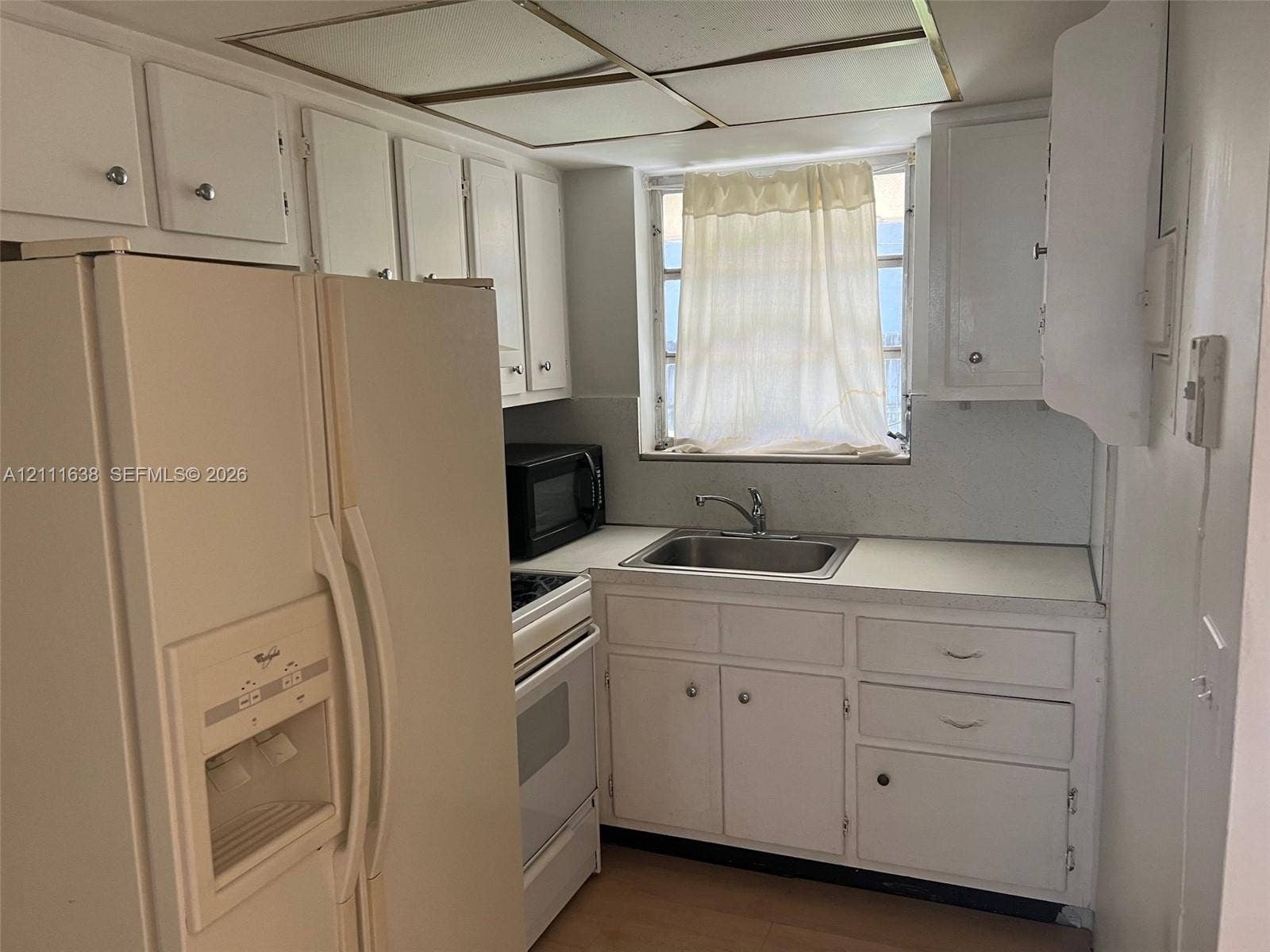 4841 SW 45th Avenue, #2, Hollywood, Hollywood, FL 33314 Kitchen featuring white cabinetry, solid-surface countertops, stainless steel sink with metal faucet, integrated range, and drop-ceiling panel lighting
