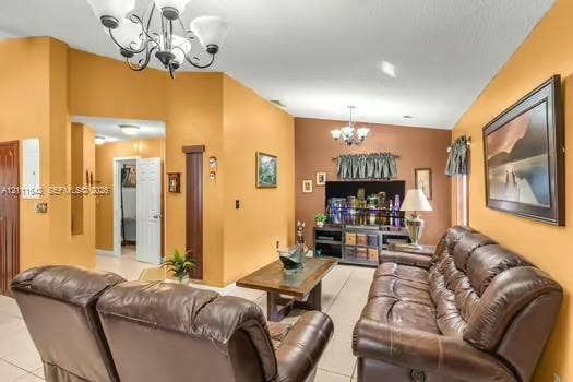 12801 SW 248th Terrace, Homestead, FL 33032 Living area featuring tile flooring, vaulted ceilings, and dual multi-arm chandeliers